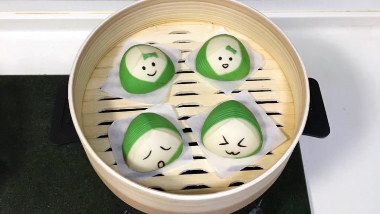粽子表情包馒头,四个粽子表情馒头完成后,放入蒸笼,锅中倒入适量的清水,待馒头发酵至1.5倍大,大火烧开,蒸10分钟。