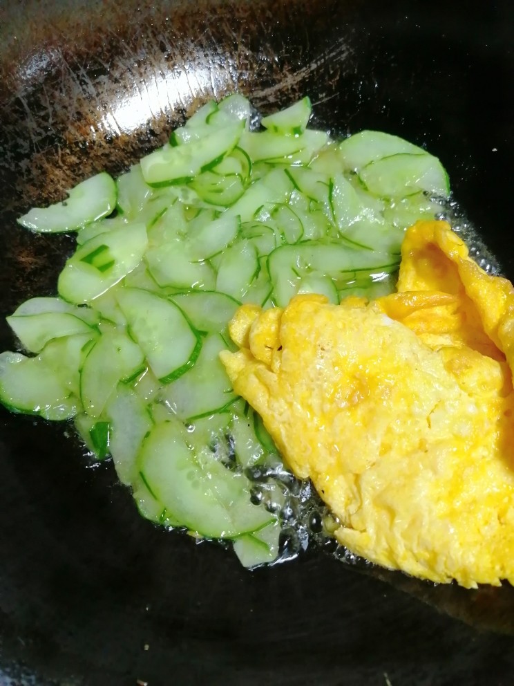 黄瓜炒鸭蛋,加煎好的鸡蛋,并用锅铲把煎蛋铲碎