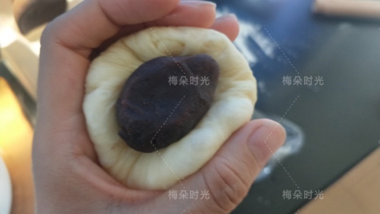 豆沙面包卷,取一个面团,稍微擀开,包入豆沙馅。捏紧收口。然后滚圆。