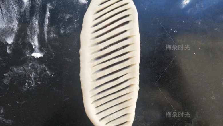 豆沙面包卷,擀成牛舌状。然后用锋利的刀子划等宽的线条。要注意。划破上面这层面,露出豆沙馅。但是不要划透底下那层面。