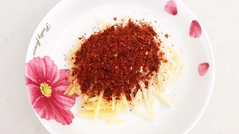 风味酱香乳瓜,把姜蒜丝放入盘里,加入<a style='color:red;display:inline-block;' href='/shicai/ 761'>辣椒粉</a>