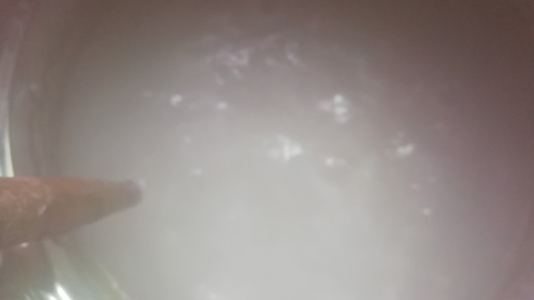 自制开心凉粉,将搅拌均匀的豌豆淀粉糊糊缓慢的倒入开水中,并调小火,期间不停的搅拌锅中的水,以免粘锅。