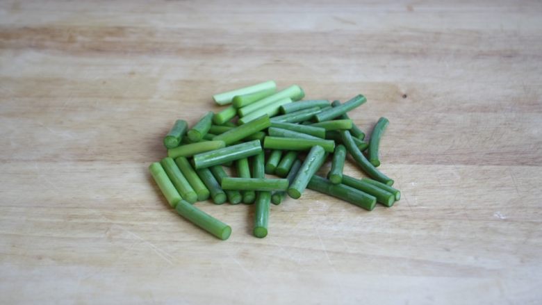 鹅蛋鸡肉炒蒜苔,蒜苔摘去老梗,切成寸段。