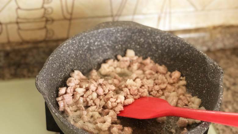 自制炸酱面,用铲子迅速划开,炒至肉丁变色。