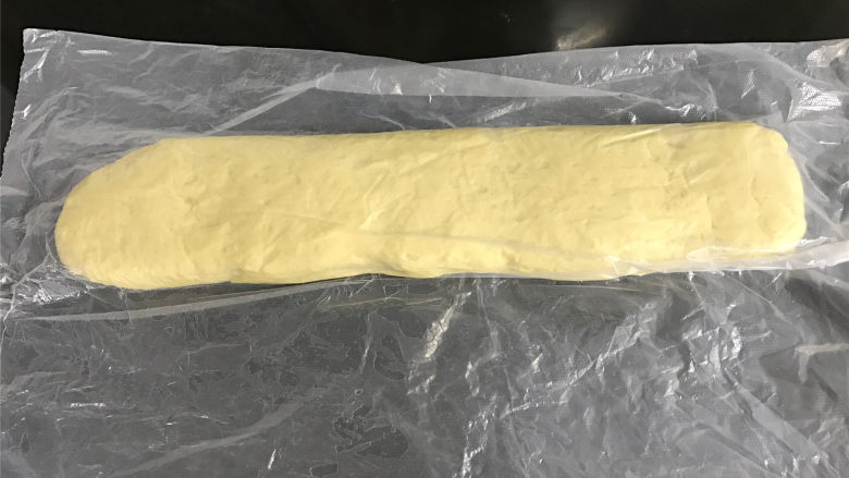自制油条,揉好的面团松驰后整成长条形,表面刷上一层油,放入保鲜袋包好,放入冰箱冷藏1个晚上。