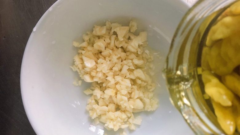 蒜香蒸茄子(泡椒蒜泥版),碗中放蒜末,放入一些泡椒水。