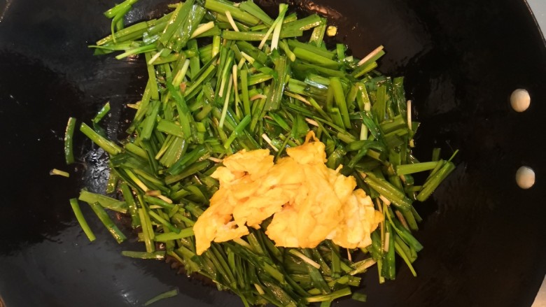 韭菜炒鸡蛋,韭菜翻炒均匀后,倒入鸡蛋,洒入盐