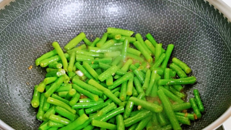 虾仁炒豇豆,加入一汤勺纯净水,将豇豆炒熟。