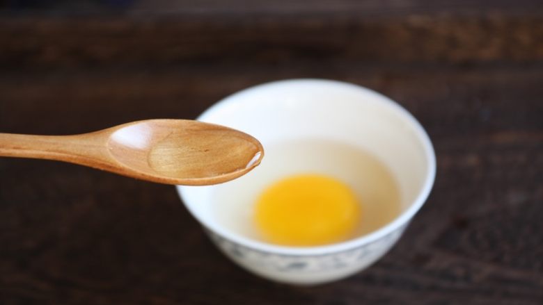 番茄鹅蛋炒豌豆卷心菜,将鹅蛋磕入碗中,放入1小勺的白糯米酒。