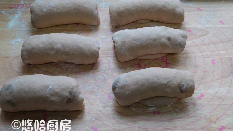 红酒葡萄干吐司,醒发后的面团翻面压扁擀长,自上而下卷起,依次做好全部面团,继续盖保鲜膜醒发20分钟左右。