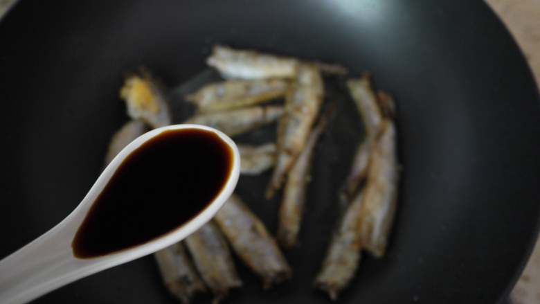 香煎多春鱼,鱼煎好后调小火,然后进行调味,加入一勺<a style='color:red;display:inline-block;' href='/shicai/ 692'>酱油</a>。稍微煮1分钟。