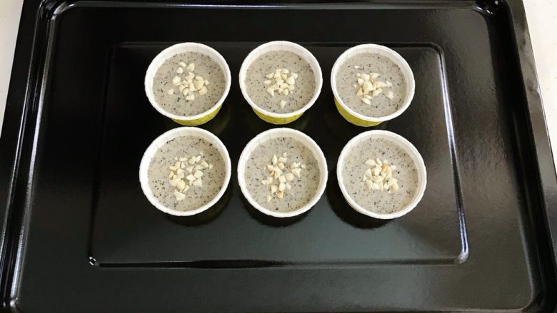 黑芝麻蛋糕杯,倒入蛋糕杯中,表面撒上少许<a style='color:red;display:inline-block;' href='/shicai/ 11221'>花生碎</a>。
