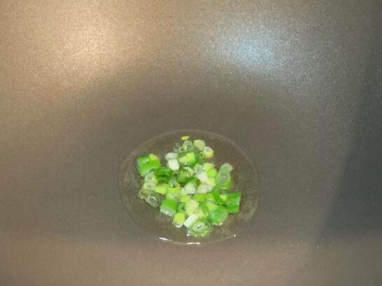 奶油酱烧鲜菇,1大匙油热锅,加入一半的葱花小火炒香。