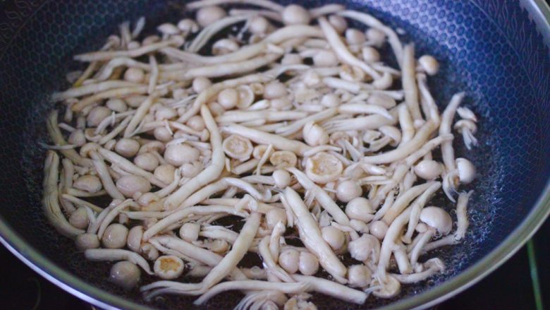 花肉白玉菇小炒,锅中倒入适量的清水烧开后,加入少许盐,把白玉菇放入锅中,煮一分钟捞出沥干水分。
