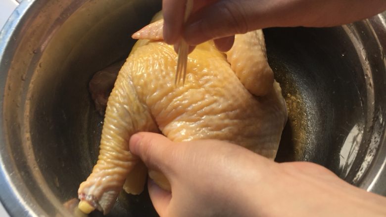 电饭煲烤鸡,用牙签把鸡肉扎扎,更好入味。再用黄酒给鸡做个按摩2分钟,放10分钟。