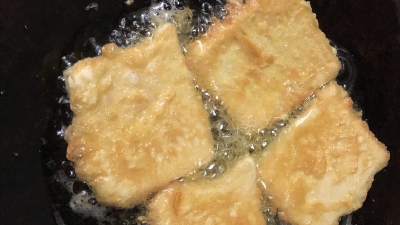 香煎鸡蛋豆腐,用筷子翻面,煎至豆腐块两面金黄即可出锅。