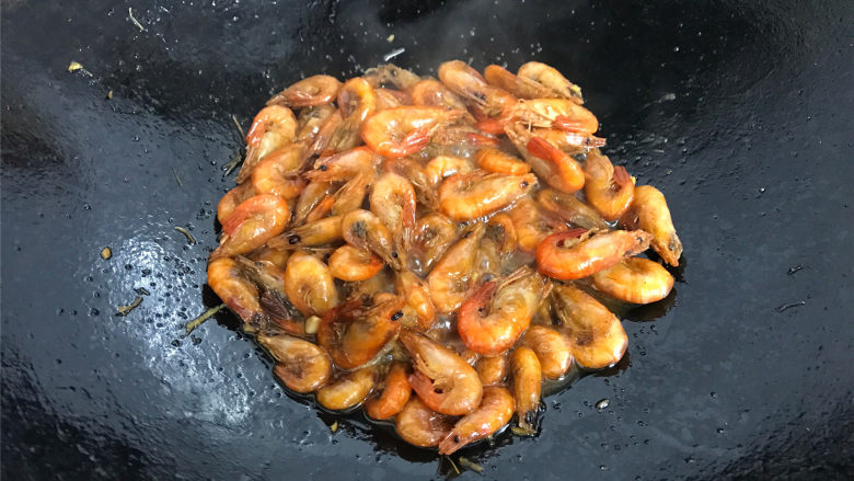 美极小河虾,把刚才炸好的虾再次倒入锅中,一起翻炒均匀后加少许水煮开。