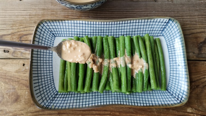 麻汁豆角,将豆角摆放在盘内，淋上麻汁即可。