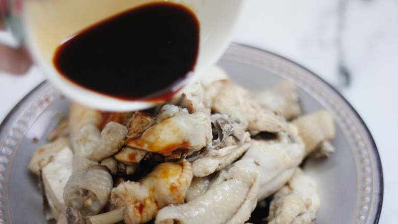 麻辣鲜香的口水鸡,逐步添加材料,将生抽酱汁淋在鸡块上,再倒上红油,加入花生和<a style='color:red;display:inline-block;' href='/shicai/ 3232'>香葱</a>。
