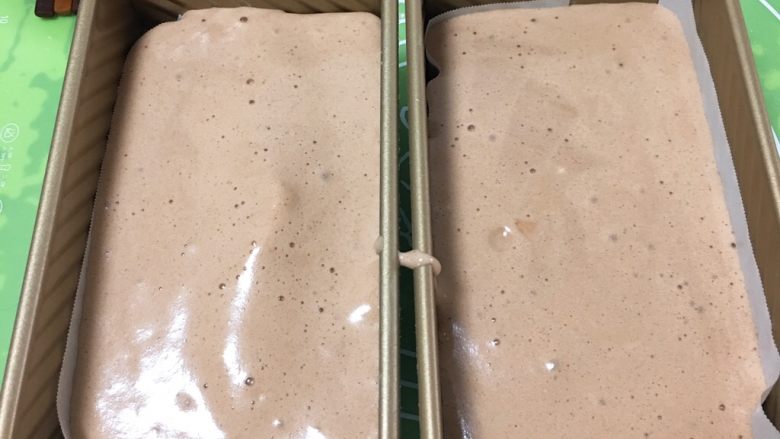 面包蛋糕混合包,将蛋糕糊倒入吐司盒一半的位子,震几下,使蛋糕糊渗入至面团细缝中。