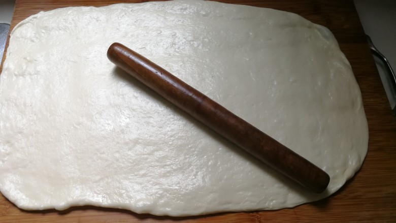 无泡打粉的油条,砧板好手上抹适量油,将面团取出来揉一揉,幹成厚厚的面片
