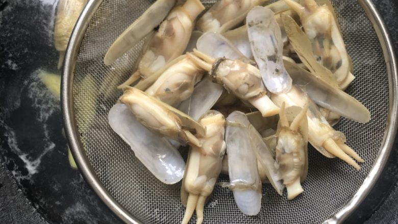 油淋竹蛏,竹蛏煮至开口,捞起来放入盆里。