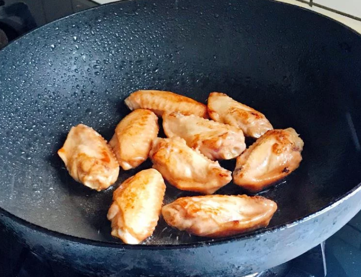 照烧鸡翅,醃好的鸡翅用中小火慢煎,煎至两边呈金黄色即可。(裡面没熟透也没关係,等一下还要燜煮)