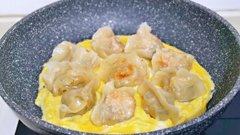 蛋抱萝卜红虾仁水饺,倒入打散的蛋液,小火慢煎至蛋液凝固。