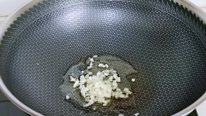 麻辣八爪鱼,锅中加入食用油,再加入蒜末炒香。