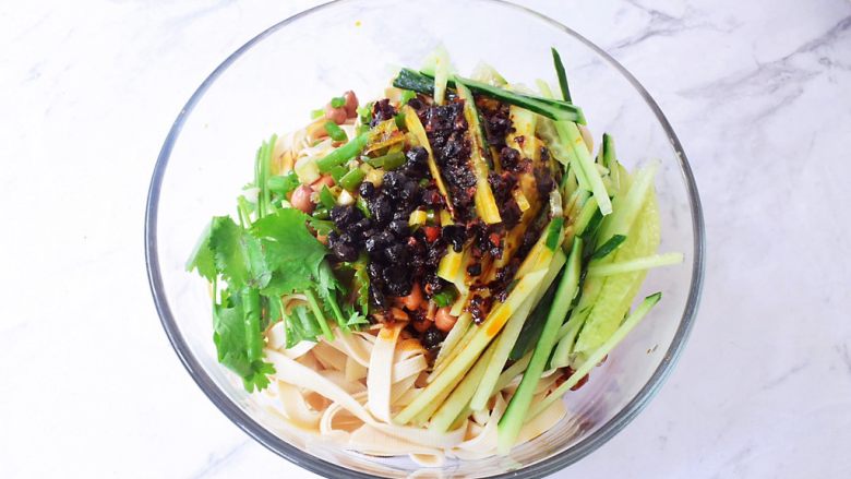 凉拌豆皮,再加入青瓜丝、葱、香菜,再淋上刚才调好的酱汁