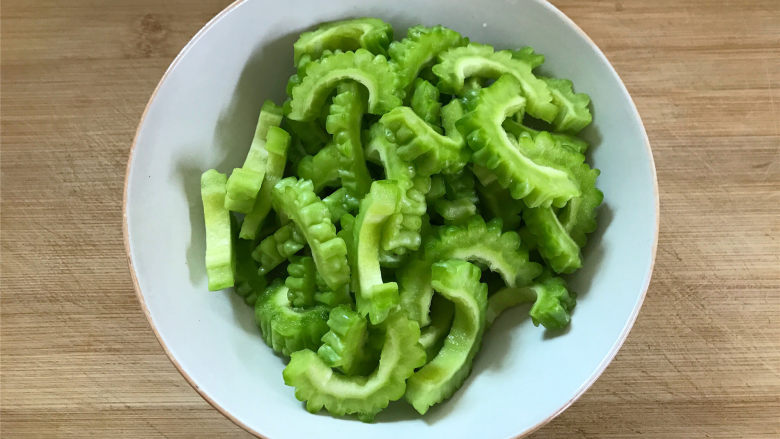 豉汁苦瓜炒牛肉,苦瓜清洗干净,去瓤后切成片,里面白色部分尽量去除得干净些,可以减少苦味。