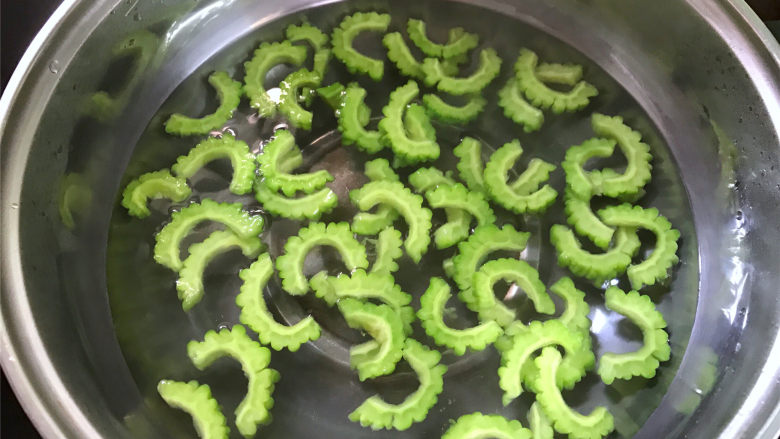 豉汁苦瓜炒牛肉,把切好的苦瓜焯下水,沥干水分后放入事先准备好的冰水中。