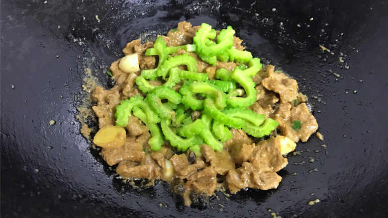 豉汁苦瓜炒牛肉,放入焯过水的苦瓜。