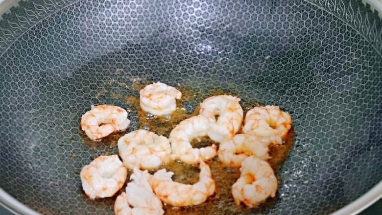 杏鲍菇炒麻辣扇贝肉,起油锅,加入虾仁煸炒,炒制虾仁变色,盛出备用。