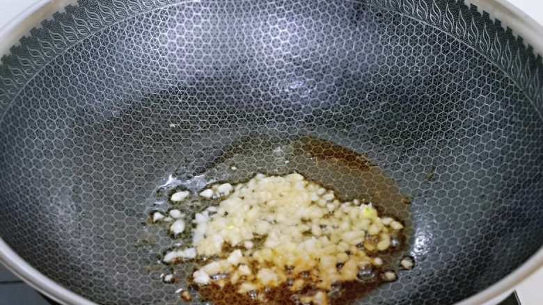 杏鲍菇炒麻辣扇贝肉,锅底留油,加入蒜末炒香。