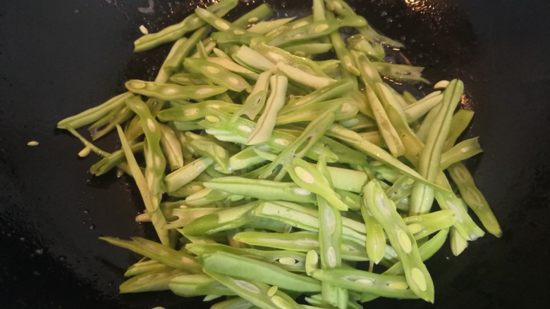 四季豆炒咸肉,锅留底油,放入四季豆,翻炒均匀,至四季豆变色