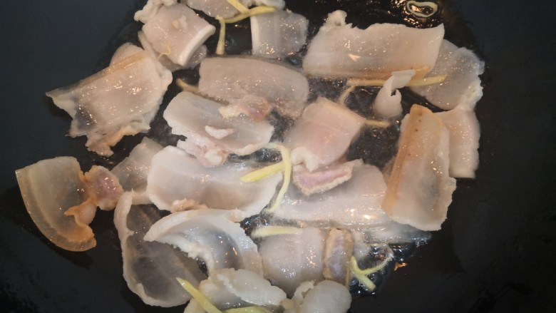 四季豆炒咸肉,把咸肉平铺均匀,小火慢煎