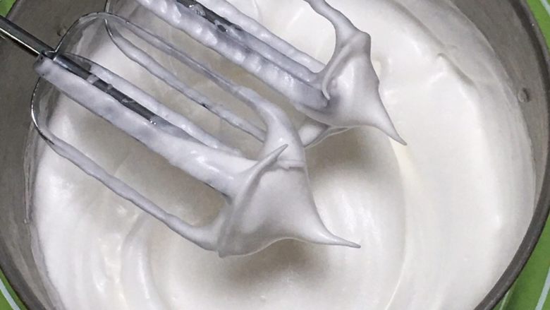 玉米粉抹茶双色蛋糕,再搅打50圈，蛋白变得硬挺，出现直立的小尖峰，蛋白打发就完成了。