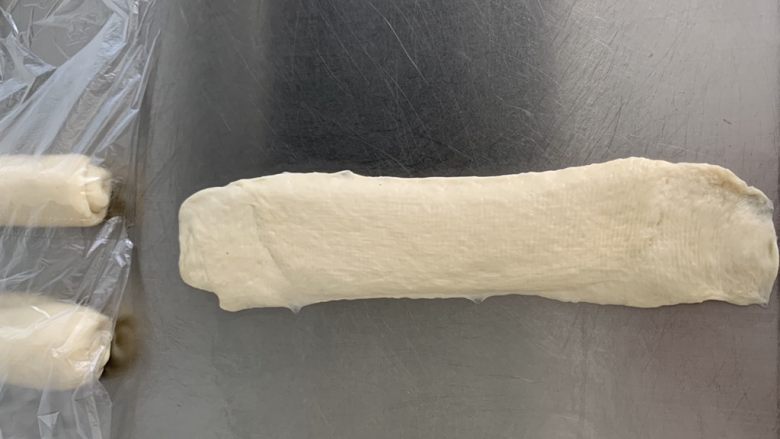 汤种酸奶吐司🍞,接口朝上再次擀成牛舌状,边缘的小气泡要轻轻拍打破。