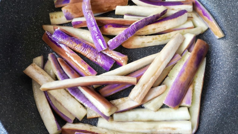 豆角烧茄子(少油健康版),将茄子煸至变软,略带透明感后盛出。