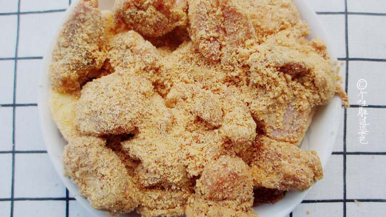 粉蒸排骨,把腌制好的肉排放在蒸肉粉里裹一圈,让蒸肉米粉能均匀的裹上排骨。拌好米粉的排骨均匀摆放在土豆的上层