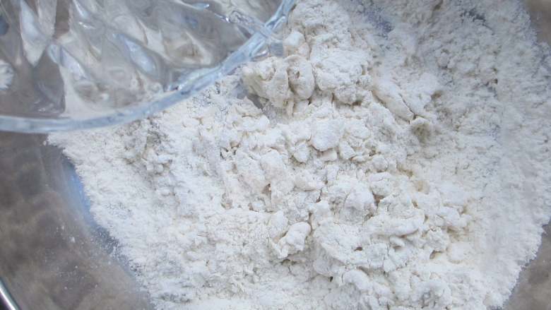 香葱味手撕饼,再一点点加入200g凉水,用筷子朝一个方向搅拌上劲,直至盆中无干面粉