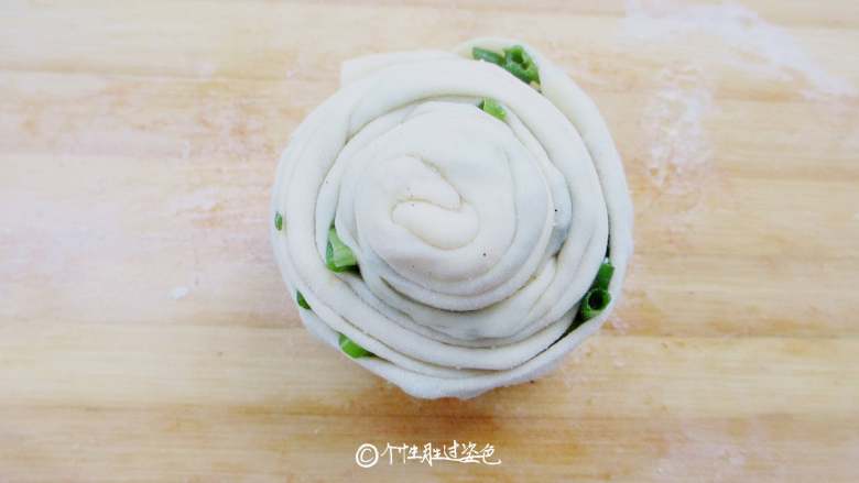 香葱味手撕饼,一边拽一边将面条盘成圆饼,收口时将面条尾端塞到饼底处捏紧