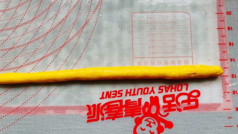 南瓜软麻花,翻面后长的一边朝下,从上往下卷成长条状。