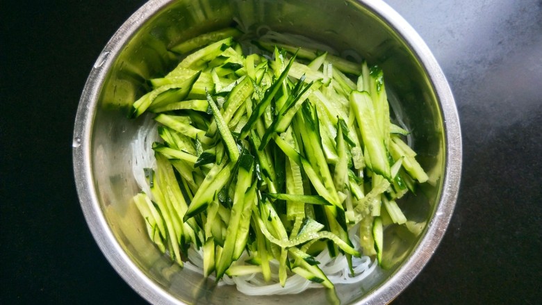凉拌酸辣粉条,米粉捞出沥干水,放入黄瓜丝。