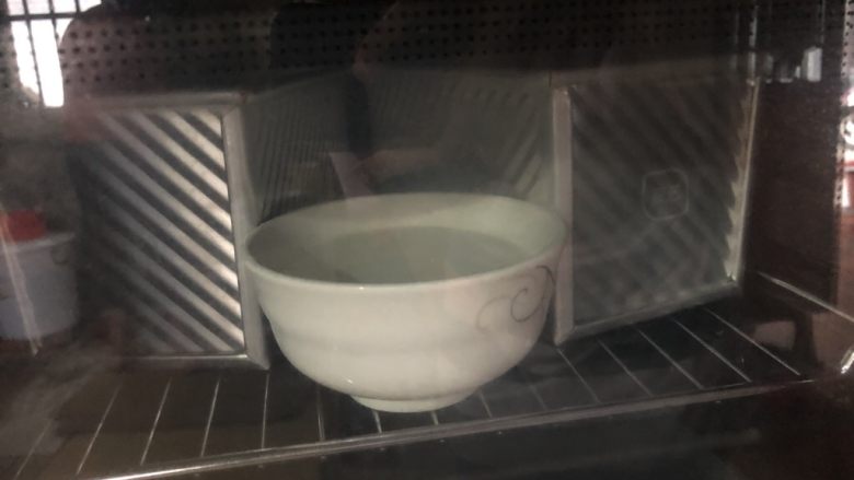 牛奶吐司,烤箱放一碗热水发酵。这里不需要开火,关上门利用烤箱的密闭性就可以