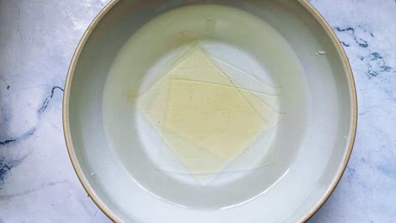 焦糖双色咖啡奶冻,首先将1片吉利丁片用冰水泡软,大概浸泡15分钟的时间。