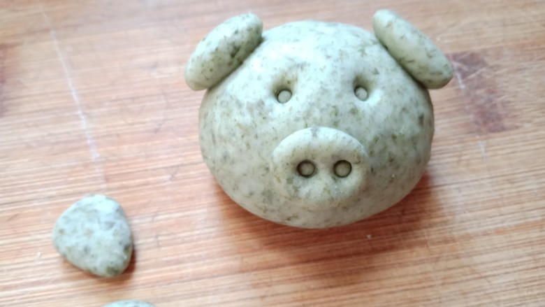 海苔猪猪馒头,将鼻子和耳朵沾水,粘到小猪头上。