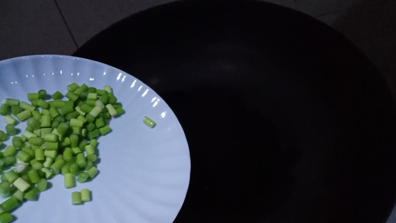 菊花茄子,炒锅内油热,倒入蒜苔碎翻炒几下