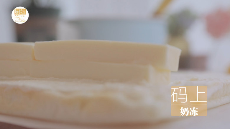 大白兔奶糖的4款甜品,烤好后取出放凉,撕掉最上层的油纸,用小刀将外端切成斜条,抹上奶油。